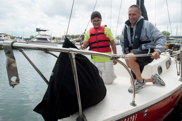 Indiana Sailing Association coach Geoffrey Barrow, on right, familiarizes Block Middle School eighth-grader Guillermo Domiguez with a sailboat July 27 during the orientation session of the Upwind learning program at the East Chicago Marina.