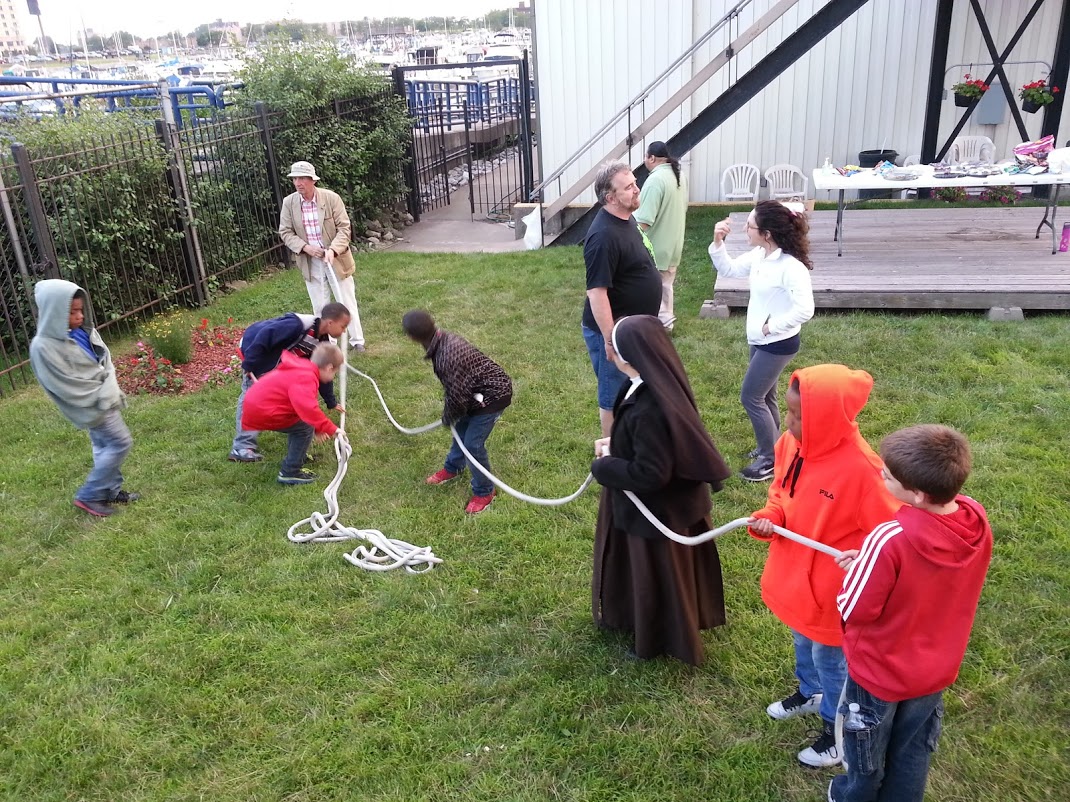 Geoffrey Barrow, Executive Director of Indiana Sailing Assocation (top left) and Sister Maria (middle holding the rope) work together each year to make the special celebration for the Carmelite Children possible.
